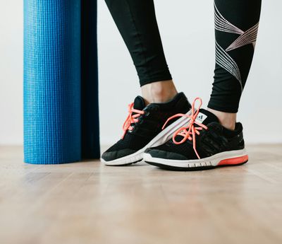 Close-up on athletic shoes on a yoga mat, ready for a workout.