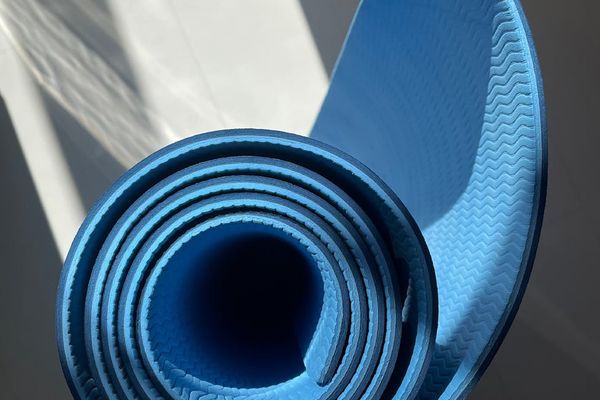 Person starting an exercise on a mat in a bright, clean room.
